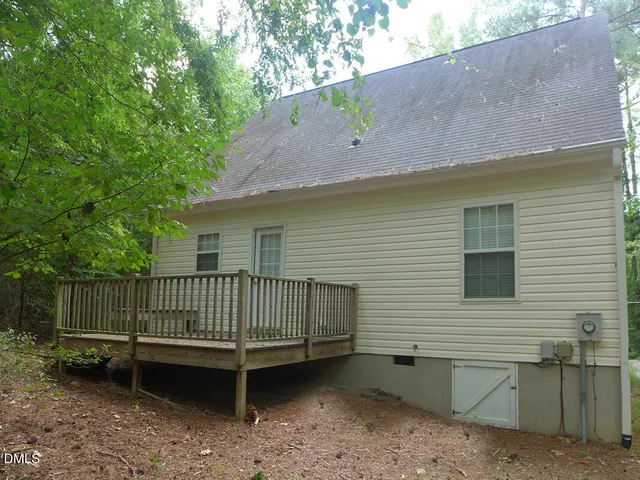 a view of a yard with a bench and wooden fence
