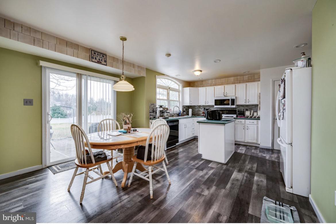 390 Wingspread Drive Reading, PA 19606 - Photo 13 of 21 a kitchen with stainless steel appliances a dining table chairs a refrigerator and cabinets