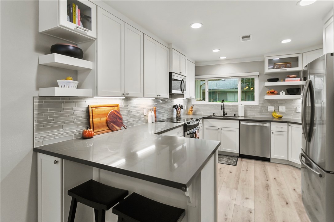 1404 North Tustin Avenue, Unit E2 Santa Ana, CA 92705 - Photo 11 of 27 a kitchen with a sink a stove and chairs