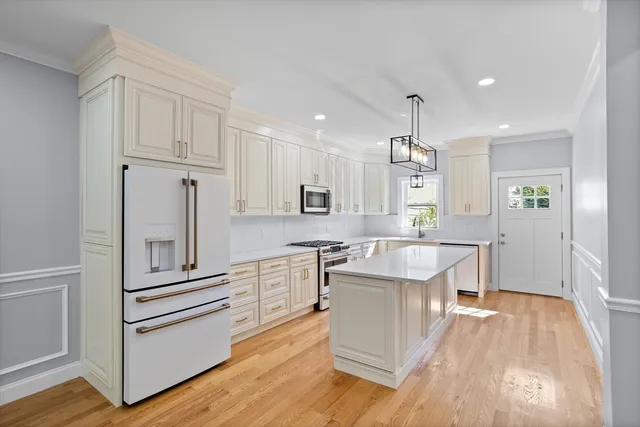 a kitchen with white cabinets and stainless steel appliances