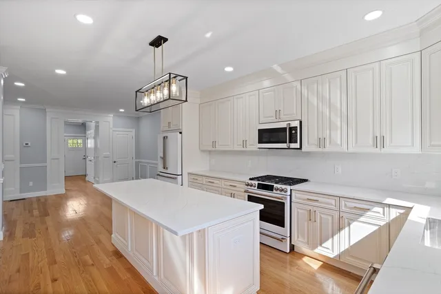 a kitchen that has a lot of cabinets and wooden floor