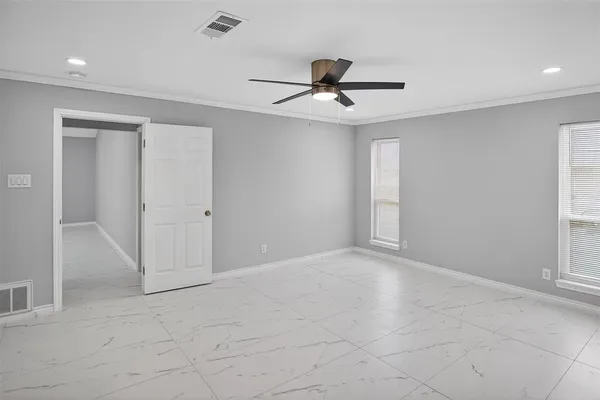 a view of a livingroom with a chandelier fan and windows
