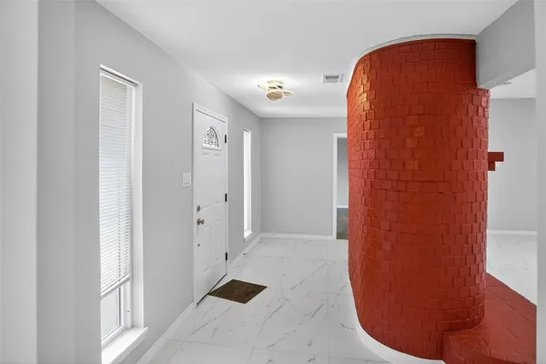 an empty room with fireplace and fan