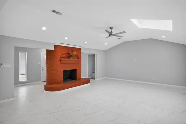 a view of an empty room with window and cabinet