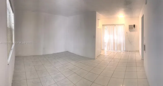 an empty room with white walls and tiles