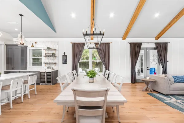 a kitchen with stainless steel appliances kitchen island granite countertop a table chairs in it and wooden floors