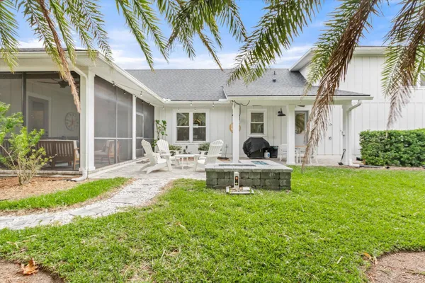 a view of a patio with table and chairs potted plants and floor to ceiling window