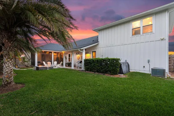 a front view of a house with a yard and trees