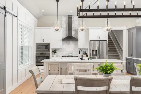 a kitchen with stainless steel appliances kitchen island granite countertop a sink a stove and refrigerator