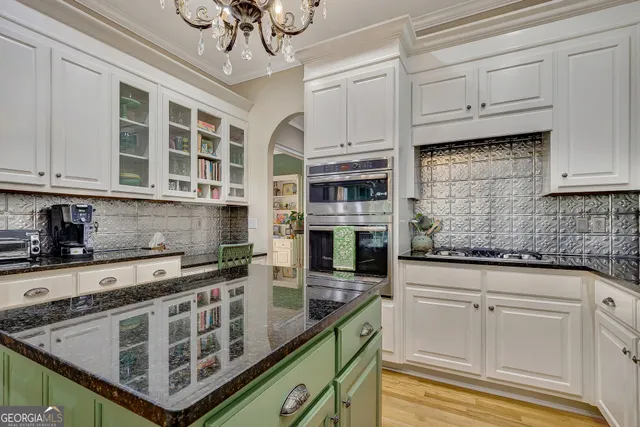 a kitchen with stainless steel appliances granite countertop a sink a stove and cabinets