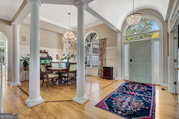 a view of a dining room with furniture a chandelier and wooden floor
