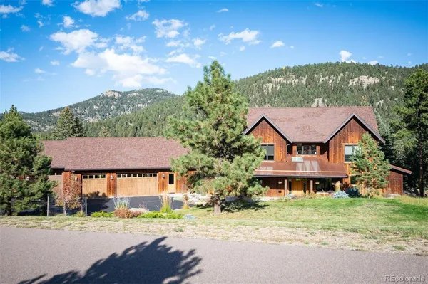 a view of a big house with a big yard and large trees