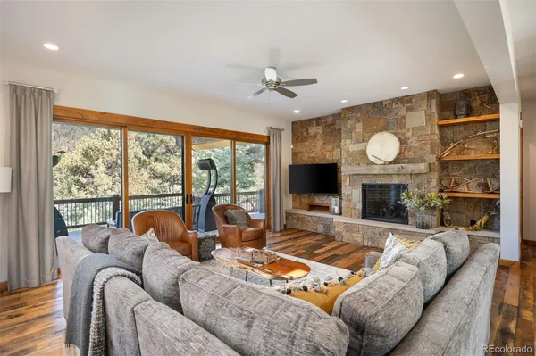 a living room with furniture a fireplace and a large window