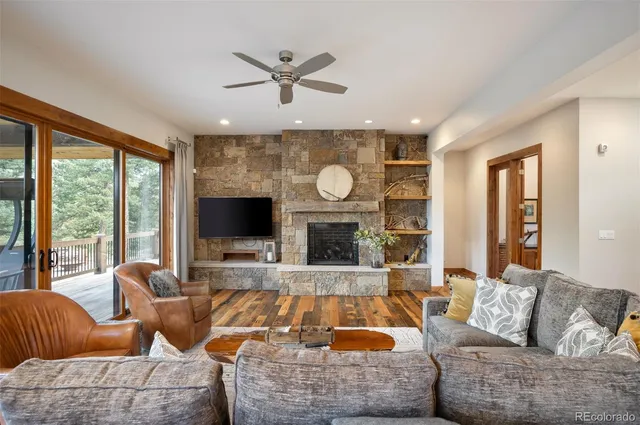 a living room with furniture a fireplace and a large window