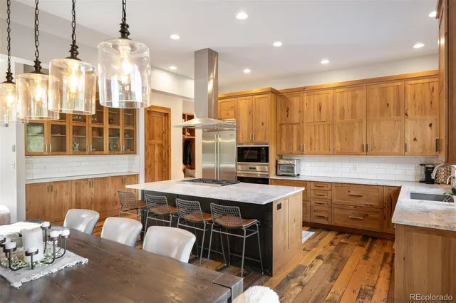 a kitchen with a table chairs sink and wooden floor