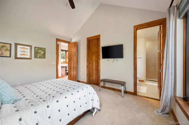 a bedroom with a bed and a flat tv screen on the wall