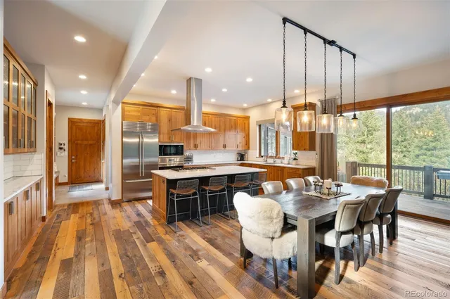 a very nice looking dining room with a large dining table and chairs with wooden floor