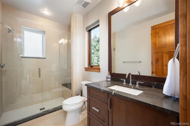 a bathroom with a sink a toilet and shower