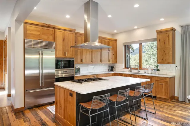 a kitchen with kitchen island granite countertop a sink stove and refrigerator