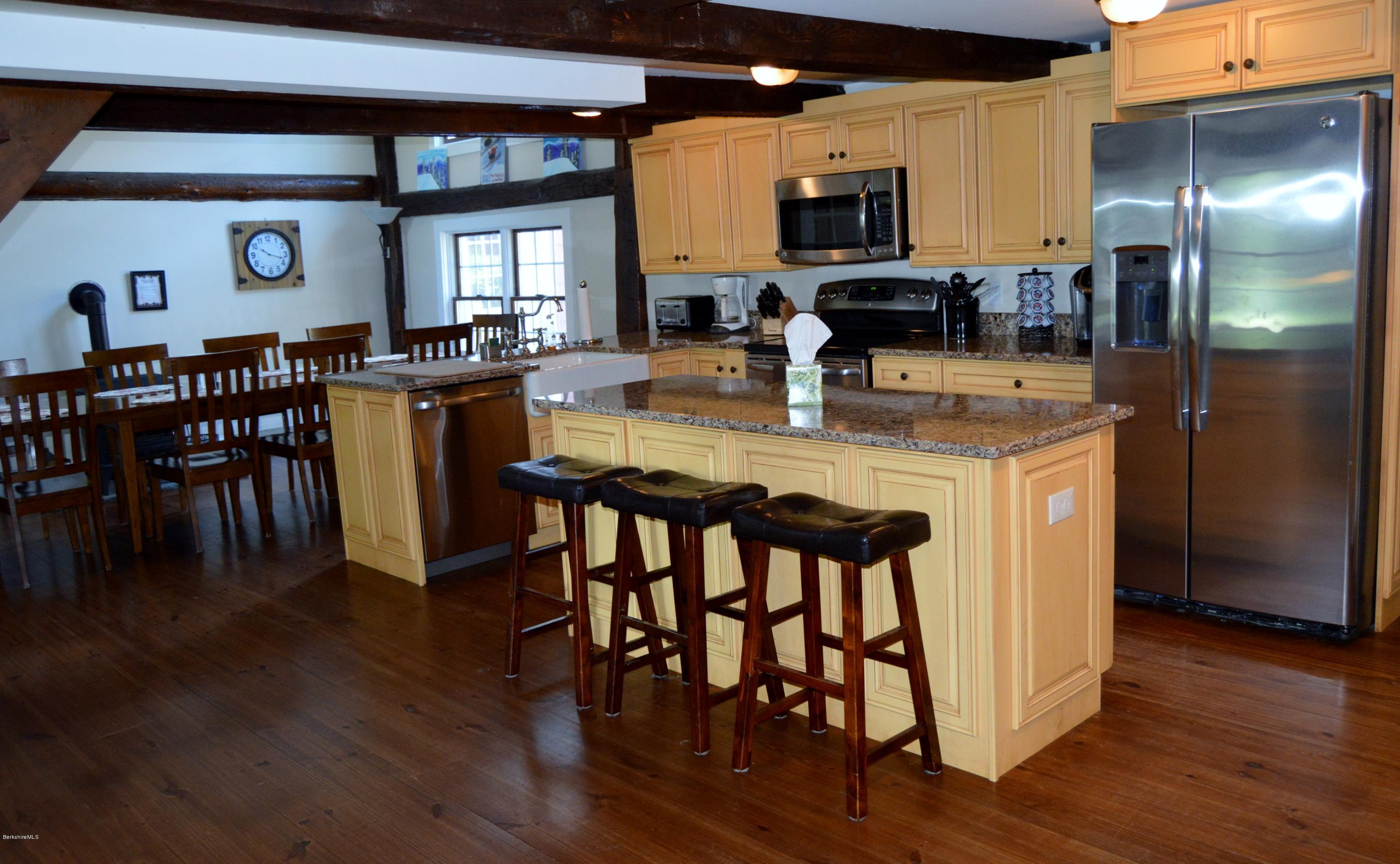 202-204 Whitman Road Hancock, MA 01267 - Photo 19 of 59 a kitchen with stainless steel appliances granite countertop a dining table chairs refrigerator and sink