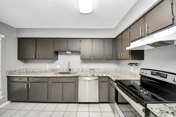 a kitchen with stainless steel appliances a sink dishwasher stove and cabinets
