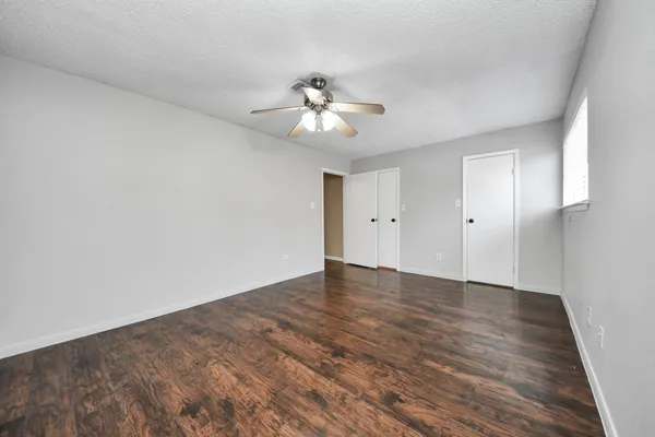 a view of empty room with wooden floor