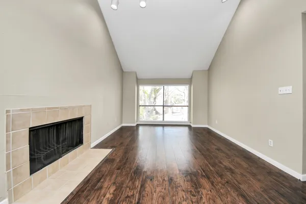 wooden floor fireplace and windows in an empty room