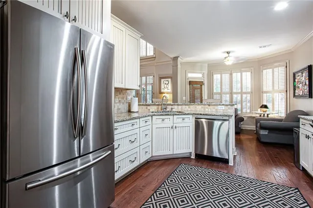 a kitchen with granite countertop a refrigerator stove top oven and sink
