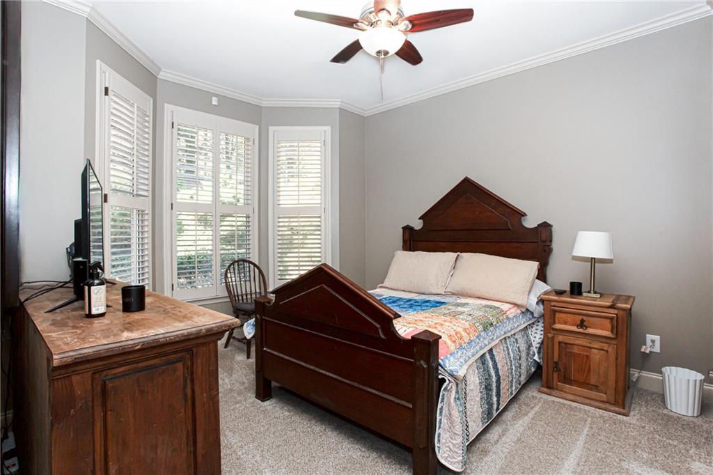 4010 Rockingham Drive Roswell, GA 30075 - Photo 15 of 36 a bedroom with a bed and a chandelier