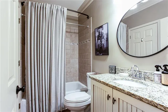 a bathroom with a granite countertop sink toilet and mirror