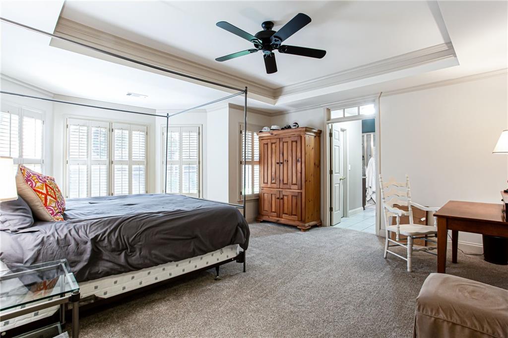 4010 Rockingham Drive Roswell, GA 30075 - Photo 19 of 36 a spacious bedroom with a bed and a chandelier