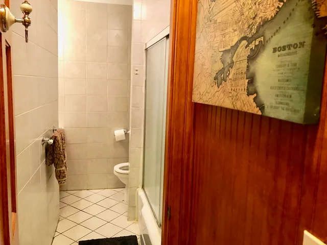 a bathroom with a granite countertop toilet and a shower