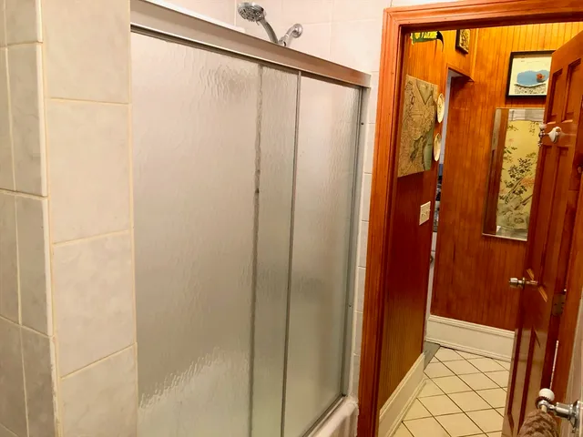 a bathroom with a shower and a glass door
