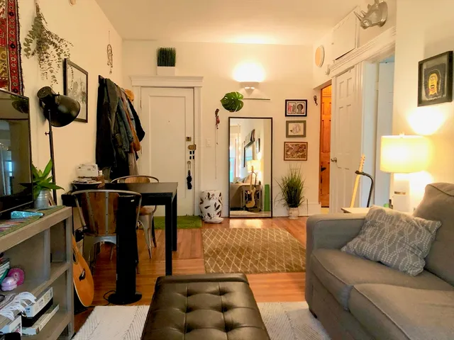a living room with furniture a lamp and large window