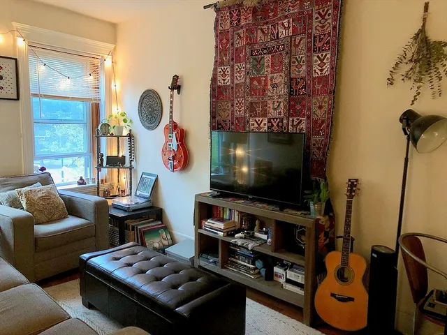 a living room with furniture a flat screen tv and a floor to ceiling window