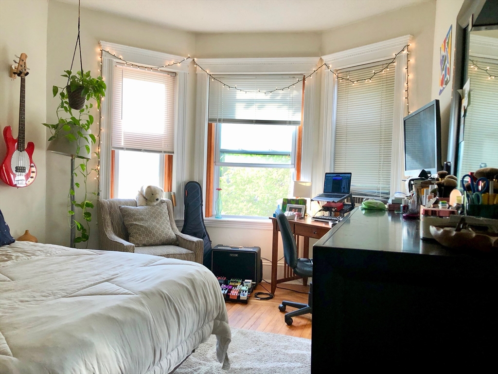 1872 Commonwealth Avenue, Unit 6 Boston, MA 02135 - Photo 7 of 18 a bedroom with a bed table chair and a window