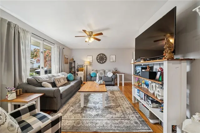 a living room with furniture a flat screen tv and a floor to ceiling window