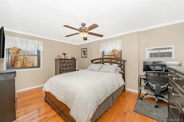 a spacious bedroom with a bed a dresser and a window