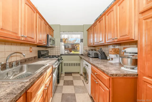 a kitchen with stainless steel appliances granite countertop a sink a stove and cabinets