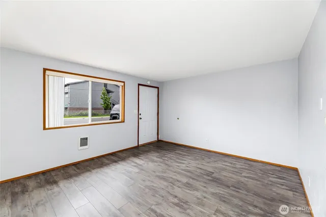 an empty room with wooden floor and window