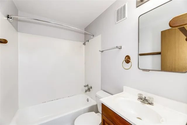 a bathroom with a sink mirror vanity and toilet