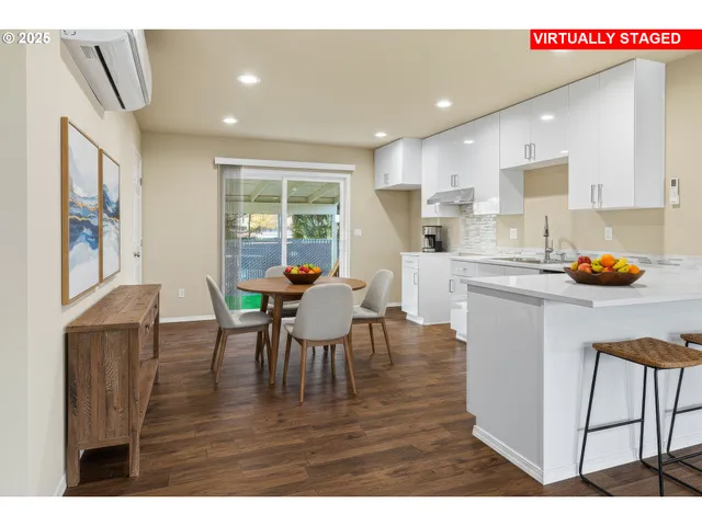 a kitchen with stainless steel appliances granite countertop a table chairs and a refrigerator