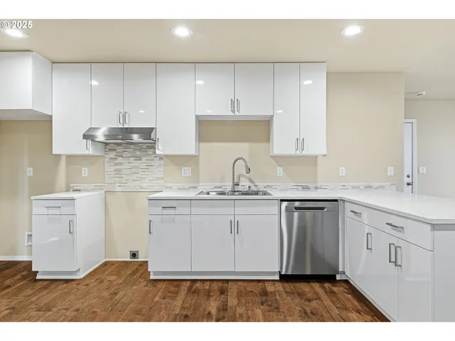 a kitchen with kitchen island granite countertop a sink cabinets and stainless steel appliances