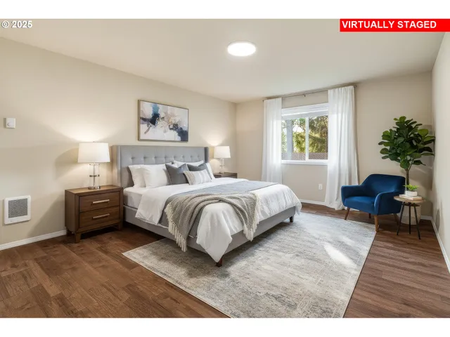 a bedroom with a bed a potted plant on dresser and a window