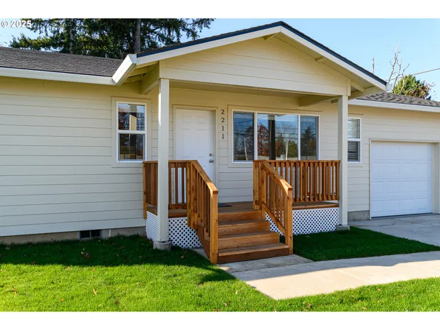 a view of a house with backyard and wooden fence