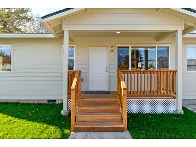 a view of a house with wooden deck and a yard