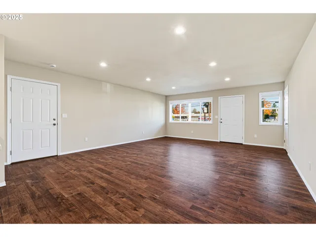 a view of an empty room with wooden floor