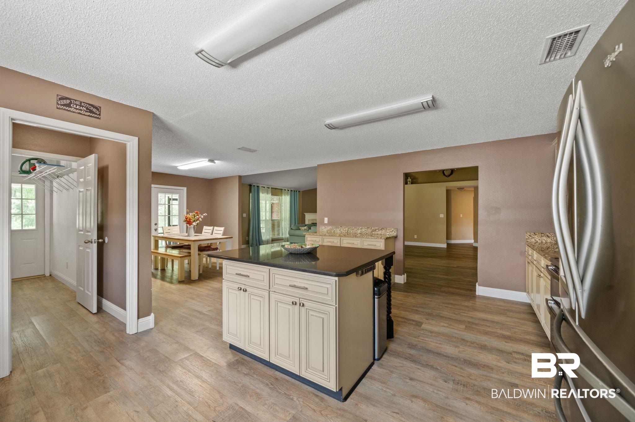 11705 Venice Boulevard Foley, AL 36535 - Photo 11 of 43 Kitchen with a textured ceiling, a center island, light hardwood / wood-style floors, and stainless steel fridge