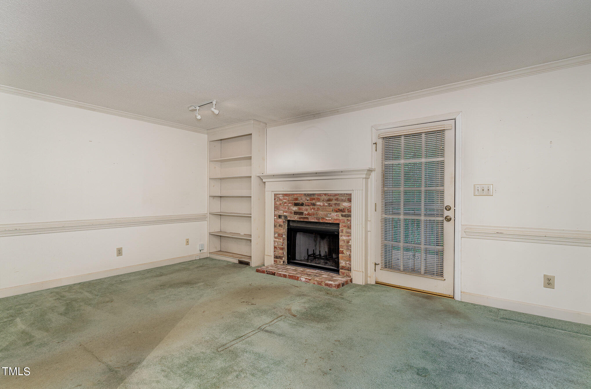 6700 Queen Annes Drive Raleigh, NC 27613 - Photo 6 of 28 a view of an empty room with a fireplace and a window