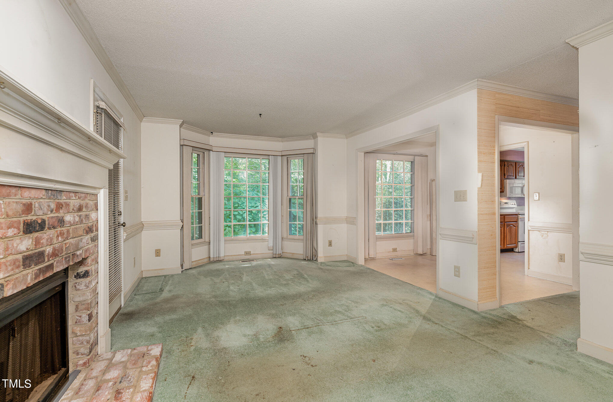 6700 Queen Annes Drive Raleigh, NC 27613 - Photo 7 of 28 a view of an empty room with a fireplace and a window